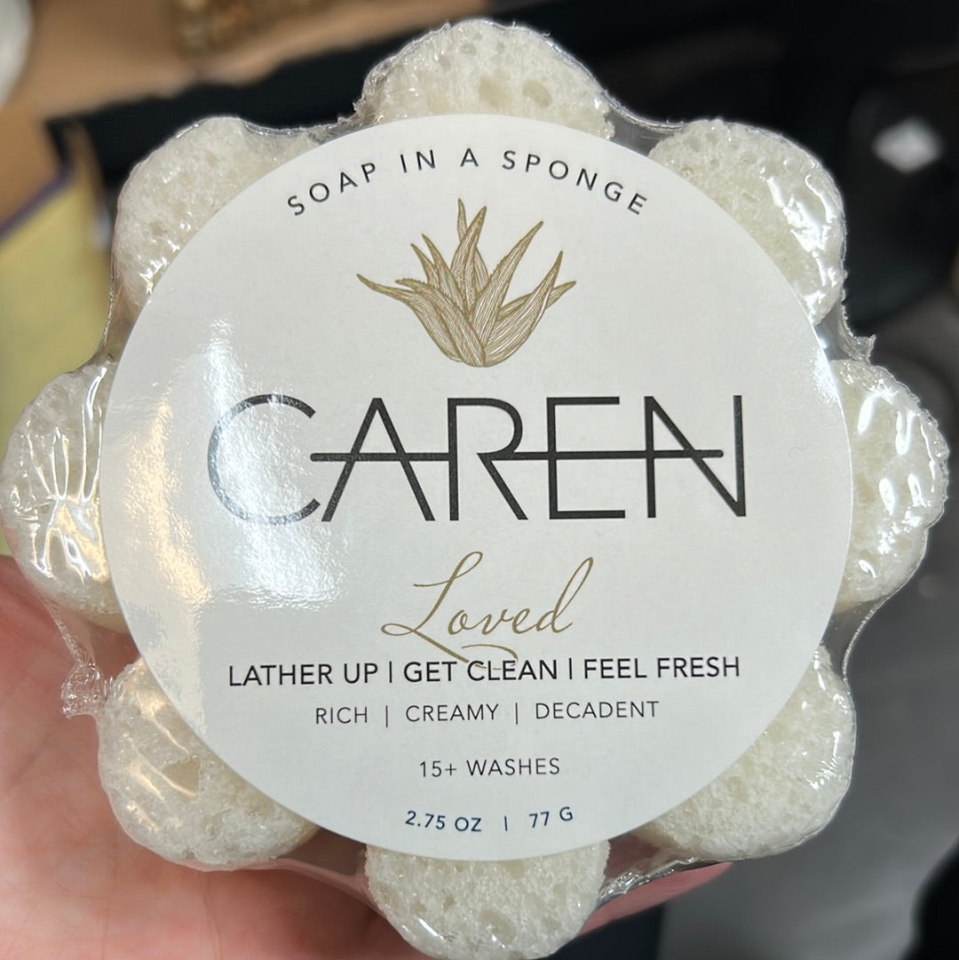 Caren "Loved" soap sponge shaped like a white flower.