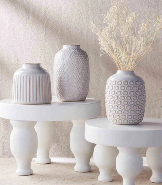 Assorted white glazed patterned ceramic vases.