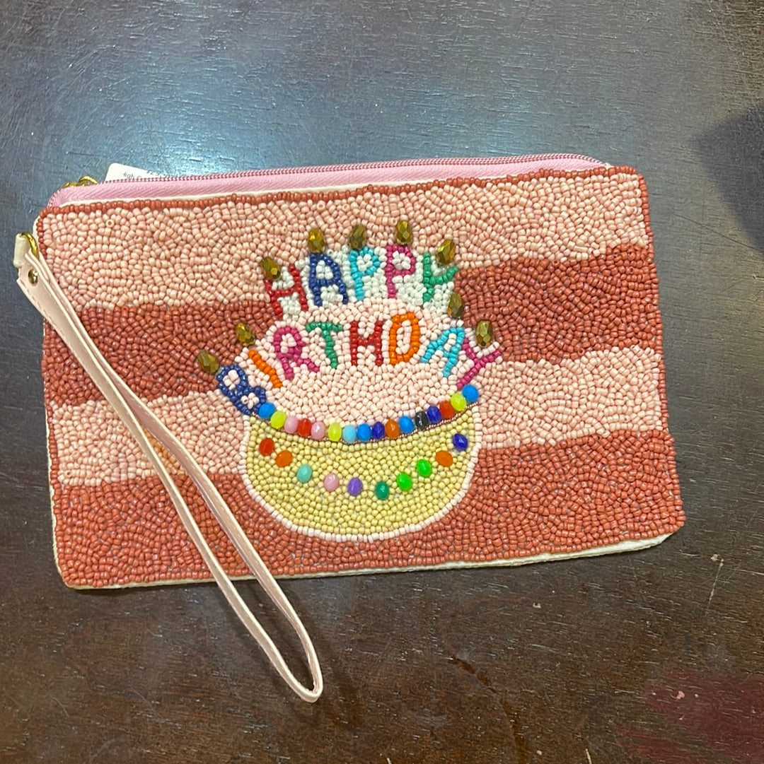 Beaded striped birthday coin bag with a wristlet that says "Happy birthday" with a cake.