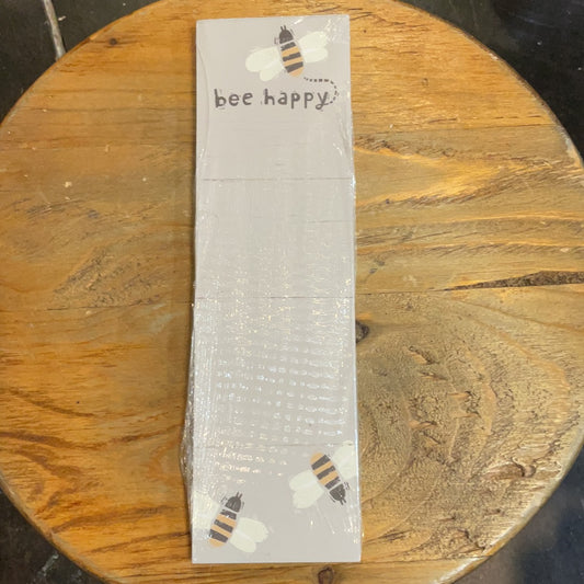 White notepad displaying "bee happy" with three bees.