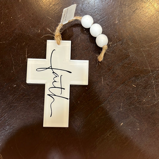 White cross hanging charm featuring the word "faith" with white beads on twine. 