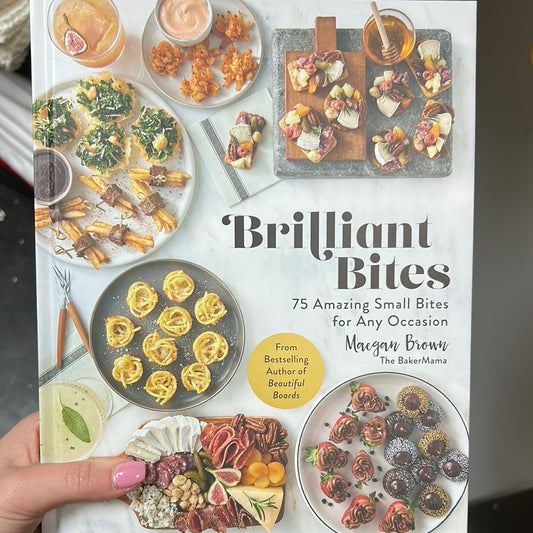 Book featuring varying charcuterie board on a white background with "Brilliant Bites" in black lettering.
