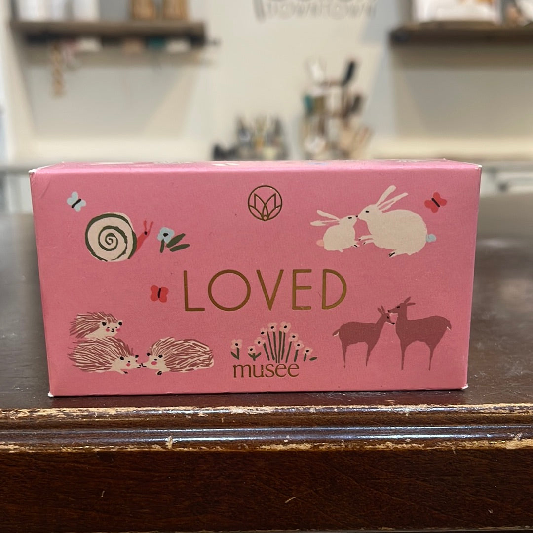 Musee Loved bar soap. Features a pink background with a white bunny, porcupines, deer and a snail.