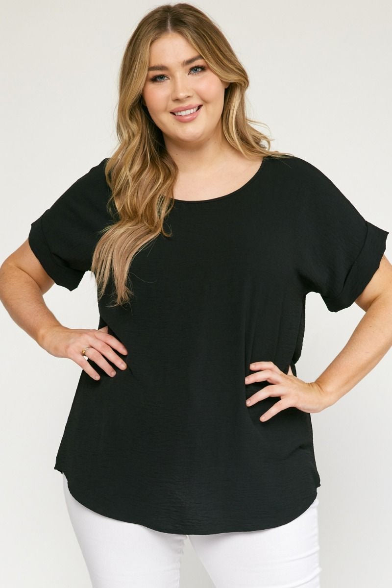 Black scoop-neck top featuring permanent rolled sleeve detail and an asymmetrical hem.