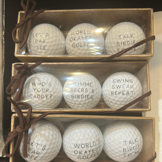 Set of golf balls with funny sayings: "Let's par tee", "World's okayest golfer", "Talk birdie to me", "Who's your caddy?", "Gimme beers & birdies", "Swing swear repeat".