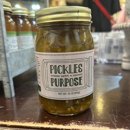 Mason jar of pickles with white and green labeling displaying "Pickles with A Purpose".