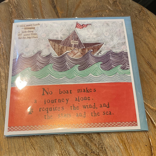 Card with a paper boat on the sea displaying "No boat makes a journey alone. It requires the wind and the stars and the sea.”