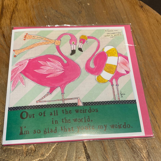 Card with two pink flamingos one with a scarf, and the other in a pool float displaying “Out of all the weirdos in the world, I’m so glad that you’re my weirdo.”.