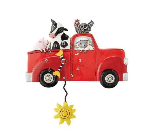 A clock shaped like a red truck with a cow and pig in the bed, a chicken on top, and a lamb inside.