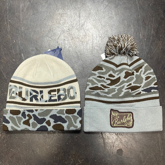 Two Burlebo beanies: White with blue and brown camo trim with "Burlebo" knitted into the hat; Light blue with brown and blue camo pattern, fuzzy pom-pom, and a Burlebo logo.