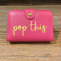 Pink pill box with button clasp featuring "pop this" in golden lettering.