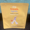 "She travels lightly" charcoal bubble detox face mask in yellow packaging.