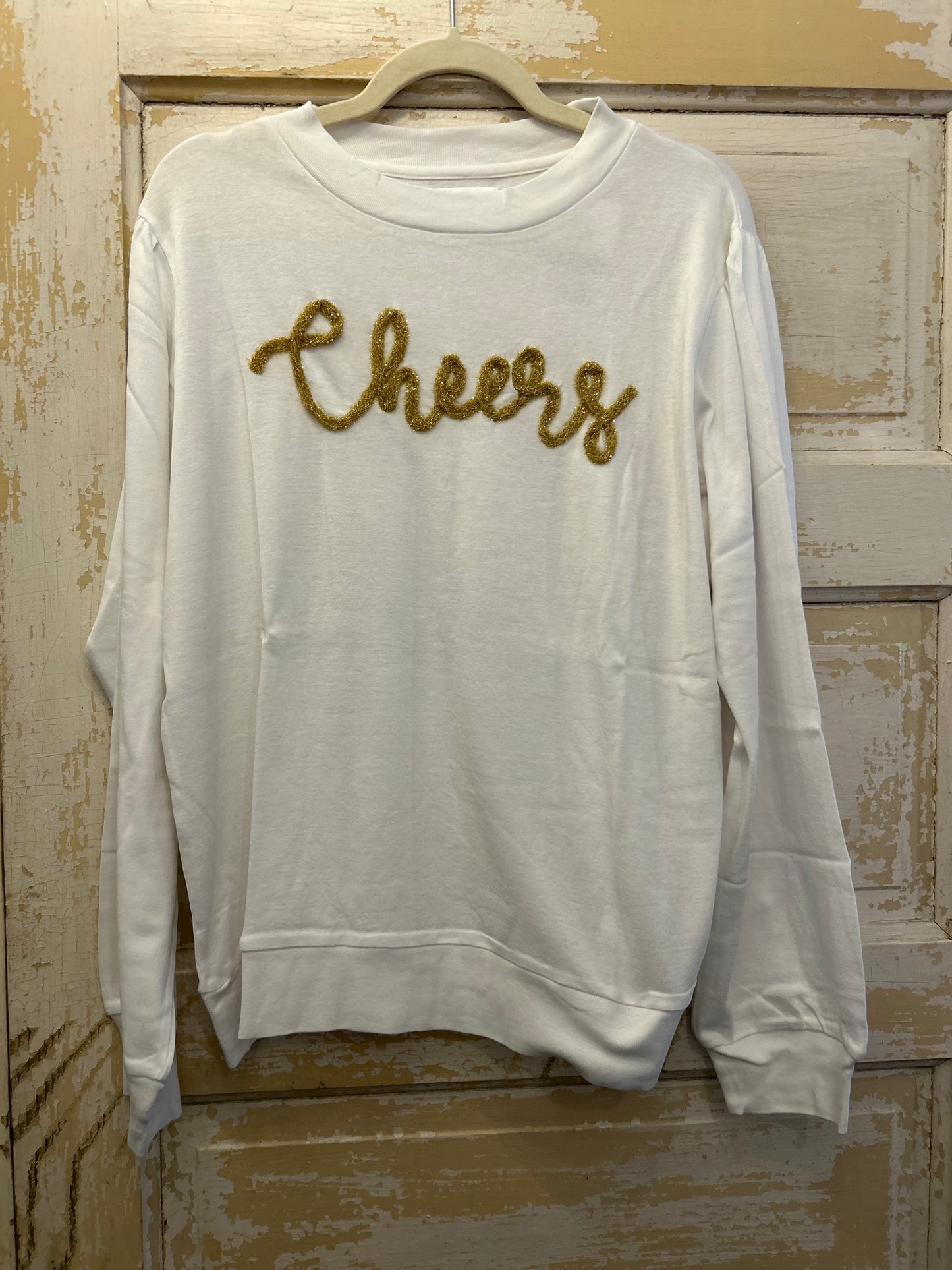 White long sleeve shirt with "Cheers" in golden glitter.