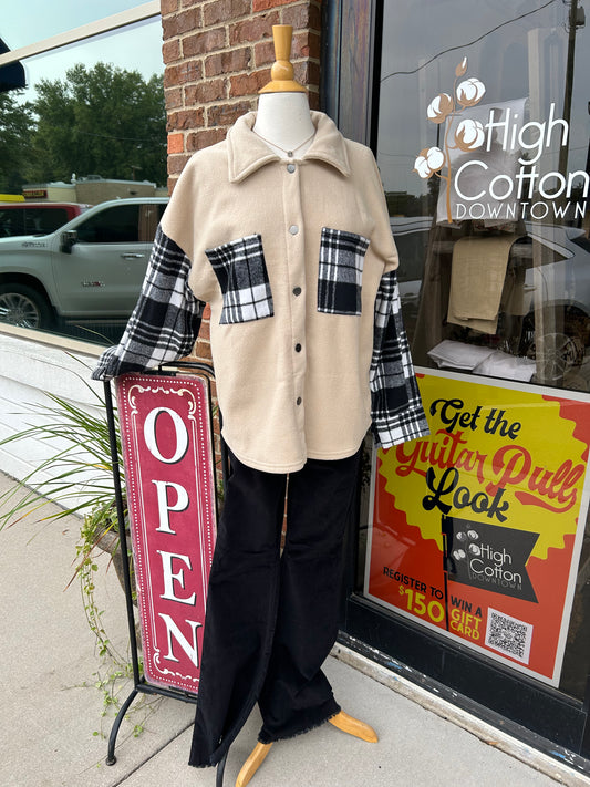 Mannequin with tan shacket with black plaid pockets and sleeves.