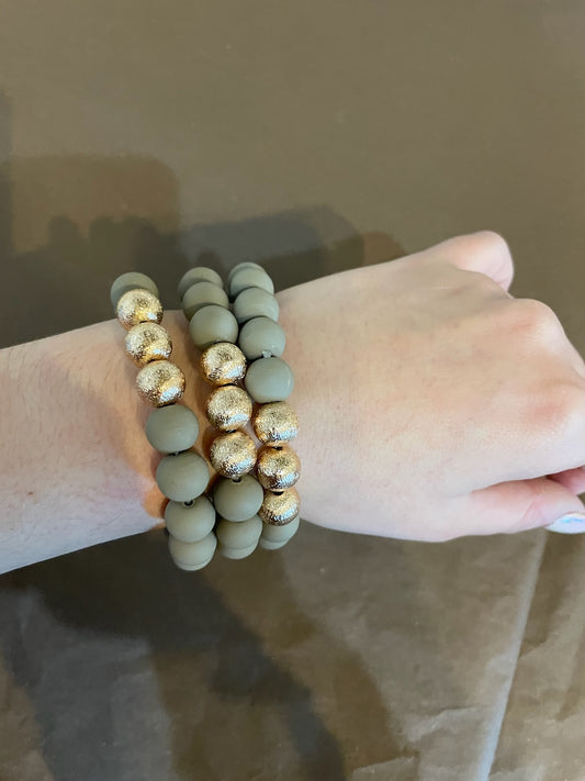 Light mocha clay textured bracelet stack with golden beads.