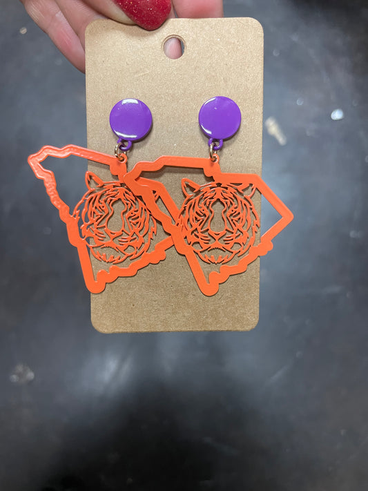 Earrings with purple stud featuring an orange tiger on the state of South Carolina.