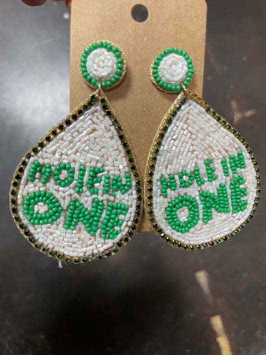 White beaded teardrop earrings featuring "Hole In One" in green beading.