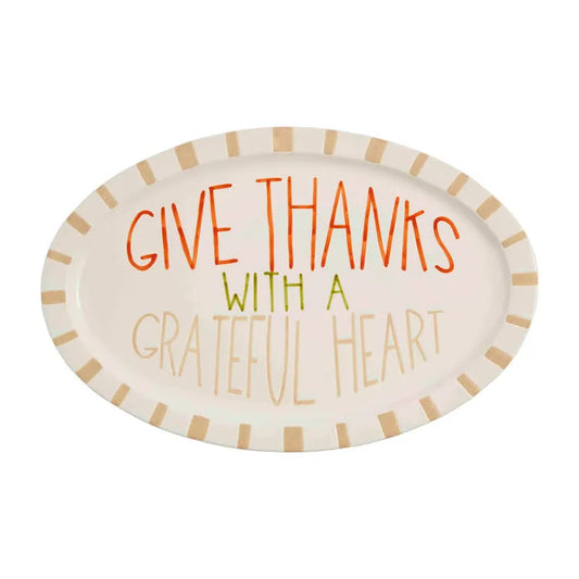 White platter featuring "Give thanks with a grateful heart" in orange, mustard and tan lettering.
