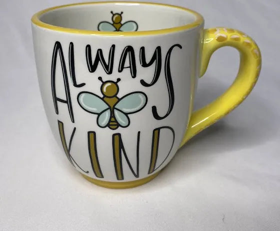 White handmade mug with yellow handle featuring "Always Kind" with a bee in the middle.