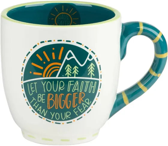 White handmade mug with teal and yellow handle featuring a mountain with trees and the sun with "Let your faith be bigger than your fear".