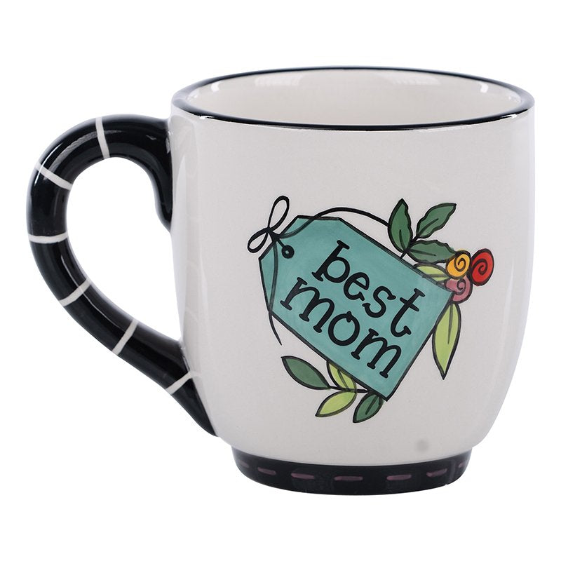 White handmade mug with black handle featuring a teal tag that says "best mom" with flowers.