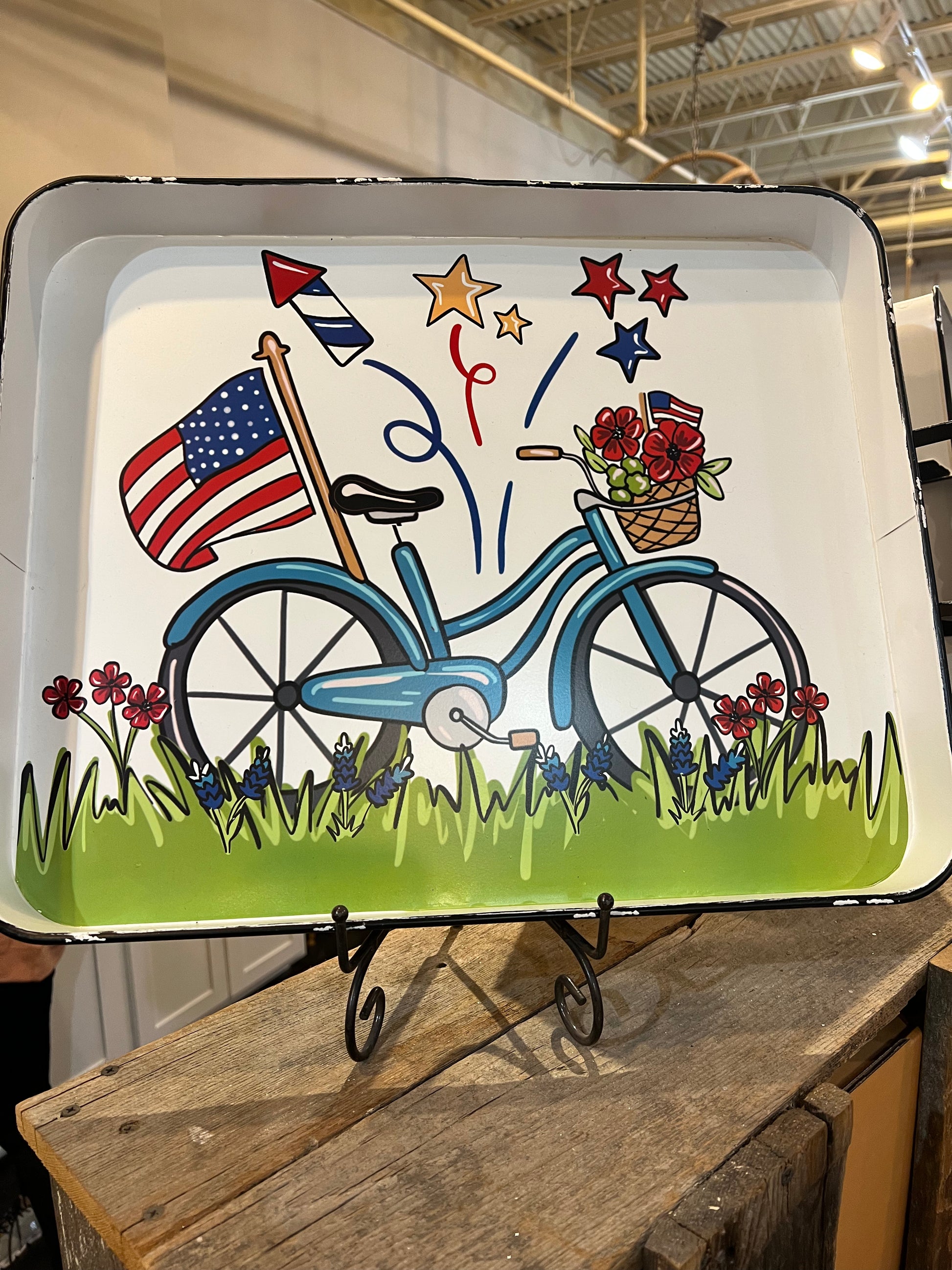 White tray with a blue bike with an American flag and fireworks.