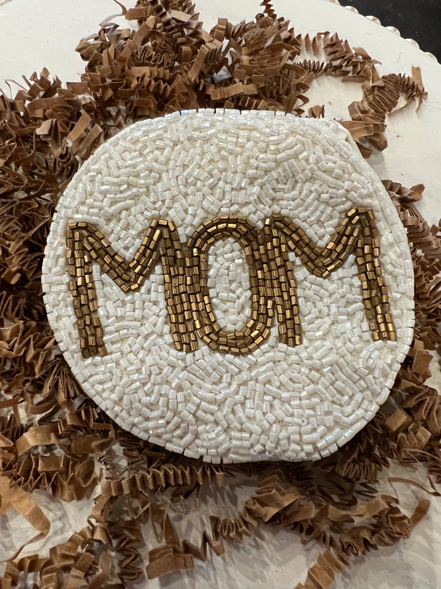 White round beaded coin bag featuring "MOM" in gold beading.