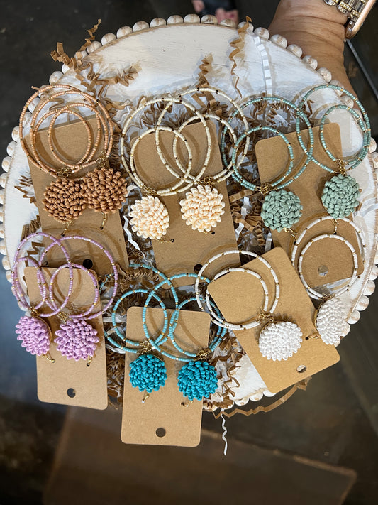 Assorted raffia studded round dangle earrings.