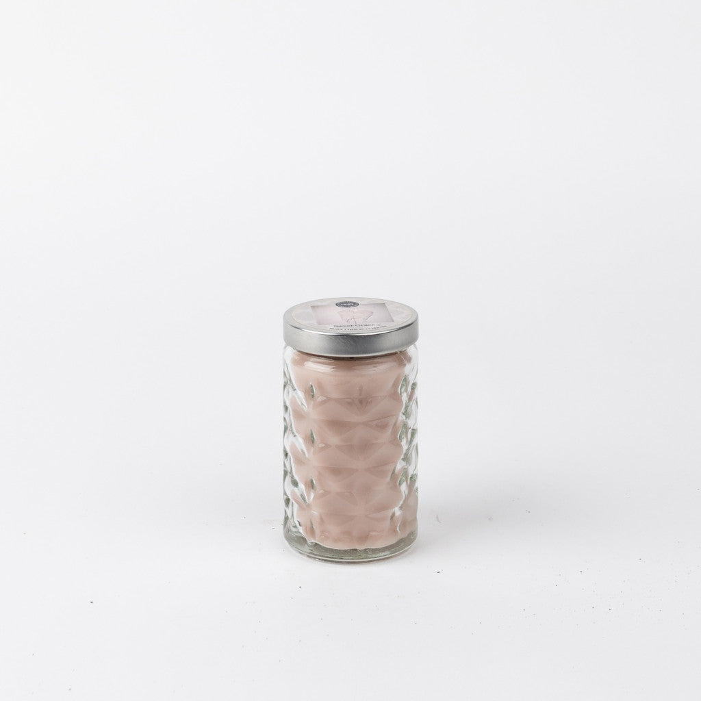 Candle in a clear, cylinder-shaped jar.