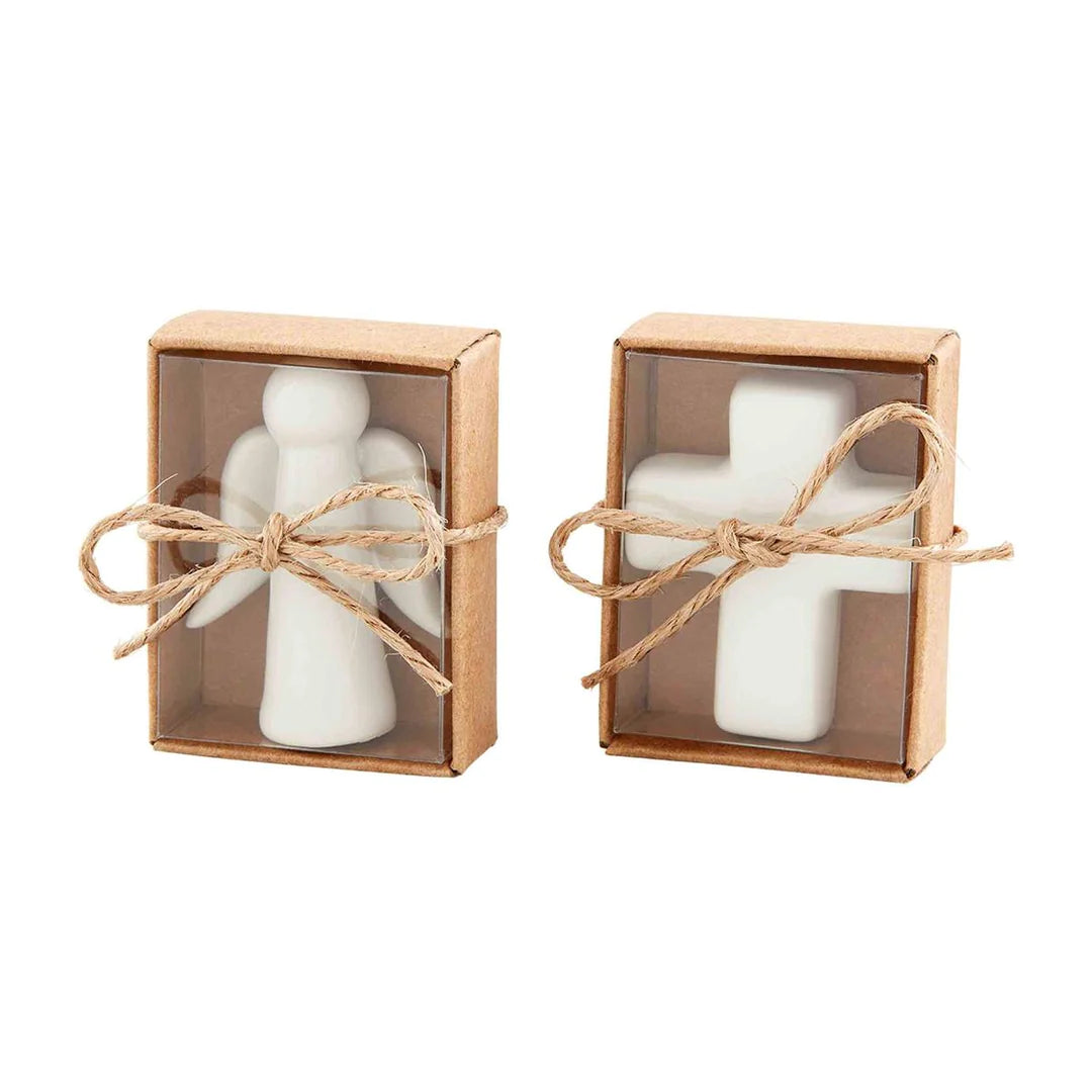White cross and angel pocket charms wrapped in a clear box with twine.