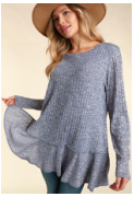 Model featuring blue women's long sleeve top with a ruffle bottom hem.