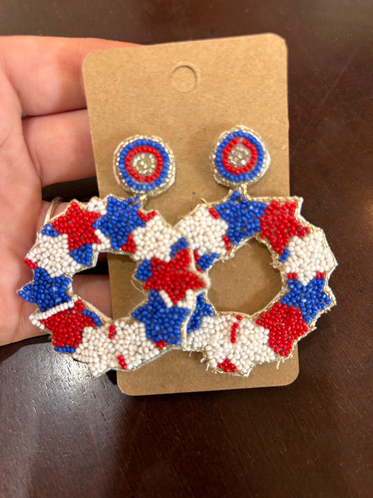 Red, white, and beaded blue earrings with stars in the shape of a circle.