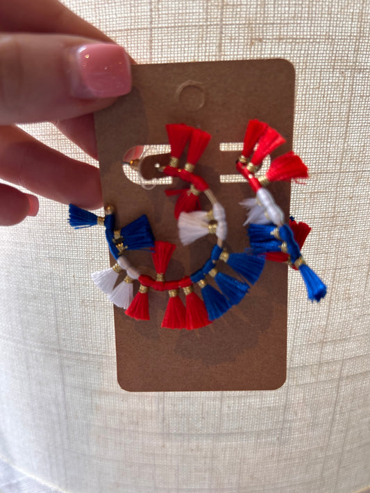 Hoop earrings with red, white, and blue tassels.